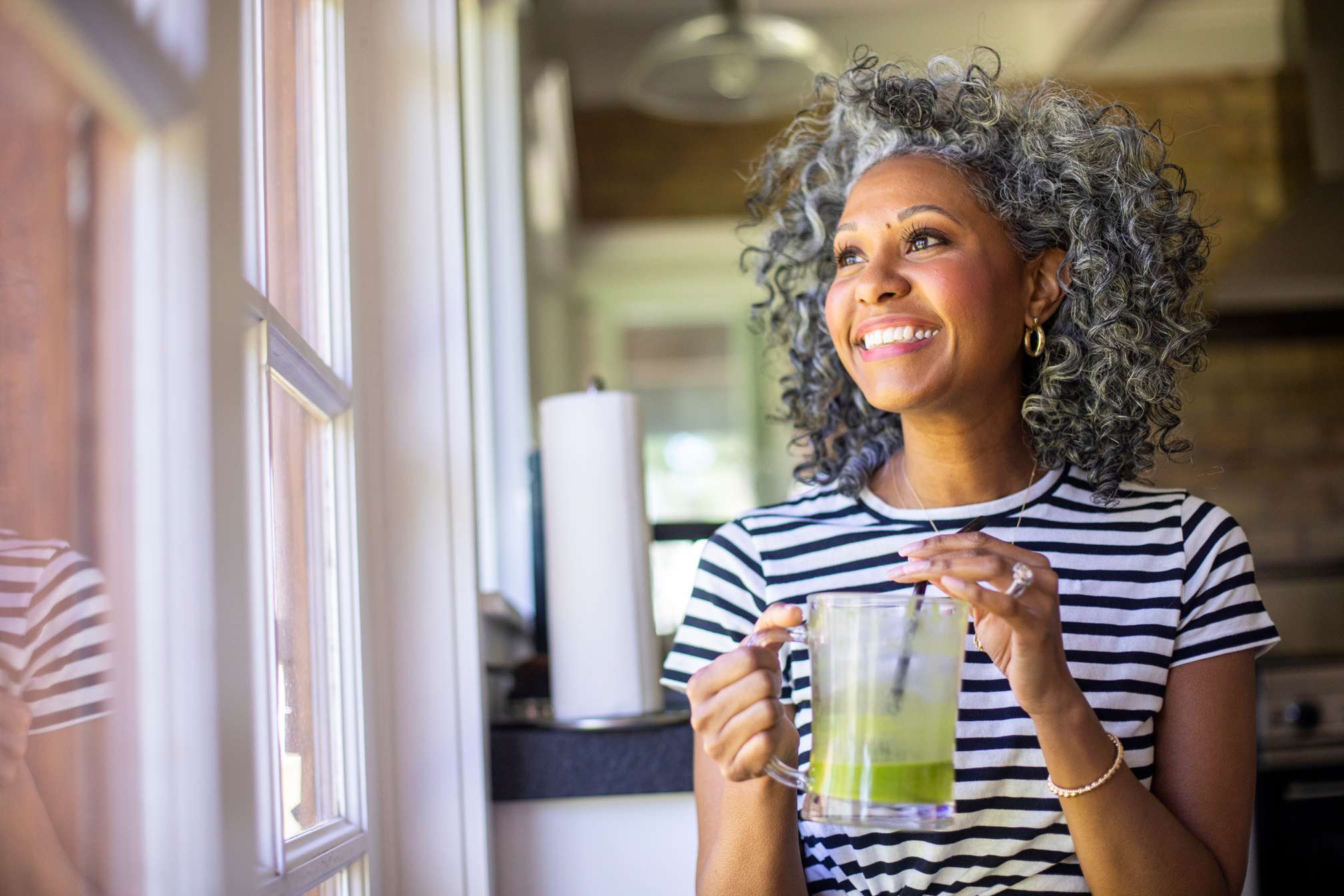 Middle-aged Black Woman Drinking a Green Smoothie